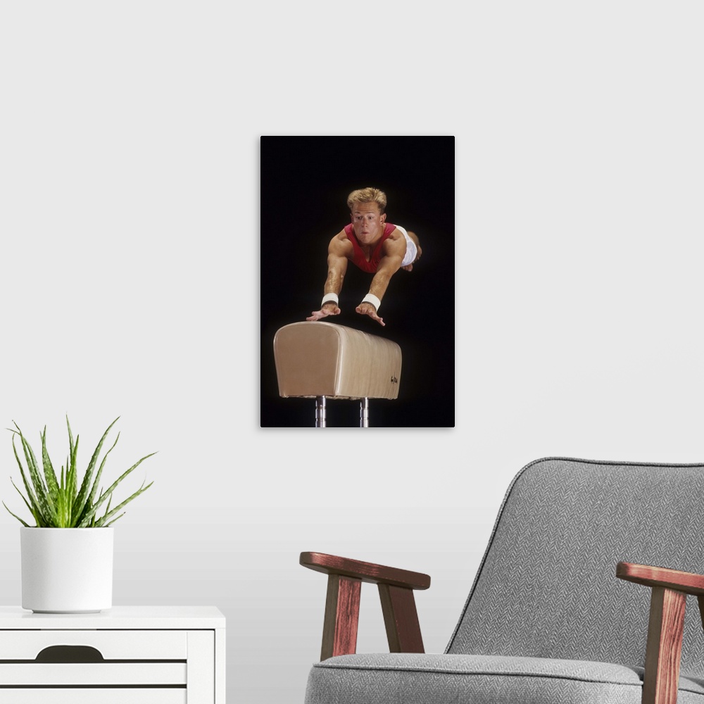 A modern room featuring Male gymnast on the vault