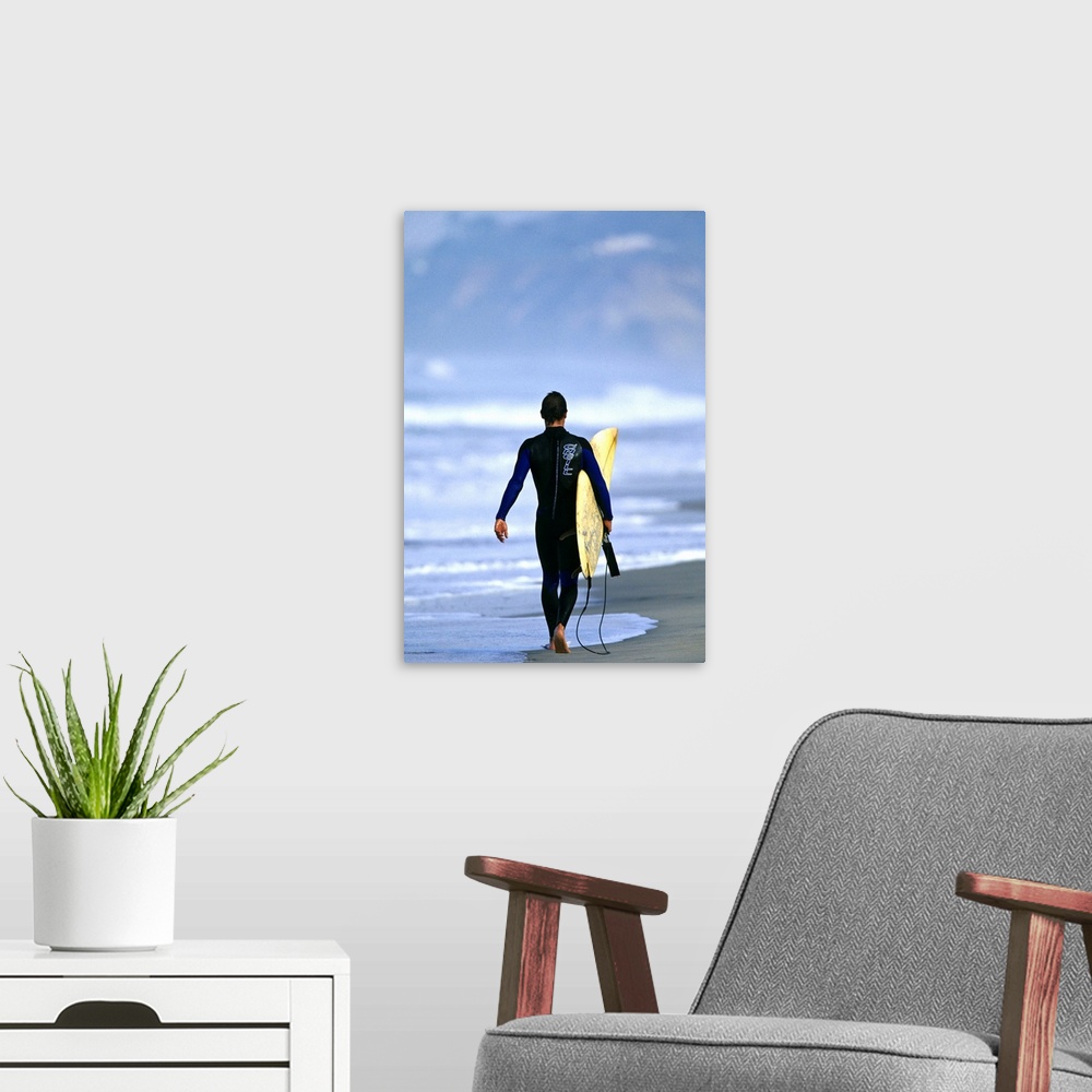 A modern room featuring Male surfer walking on the beach in San Diego, CA