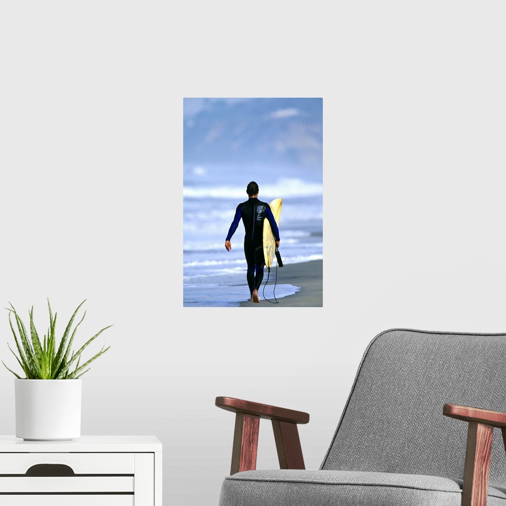 A modern room featuring Male surfer walking on the beach in San Diego, CA