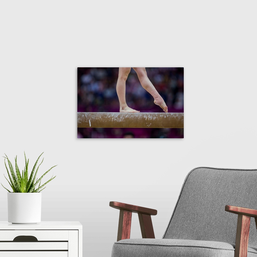 A modern room featuring Detail of gymnast  preforming on the balance beam during the women's gymnastics team finals at th...