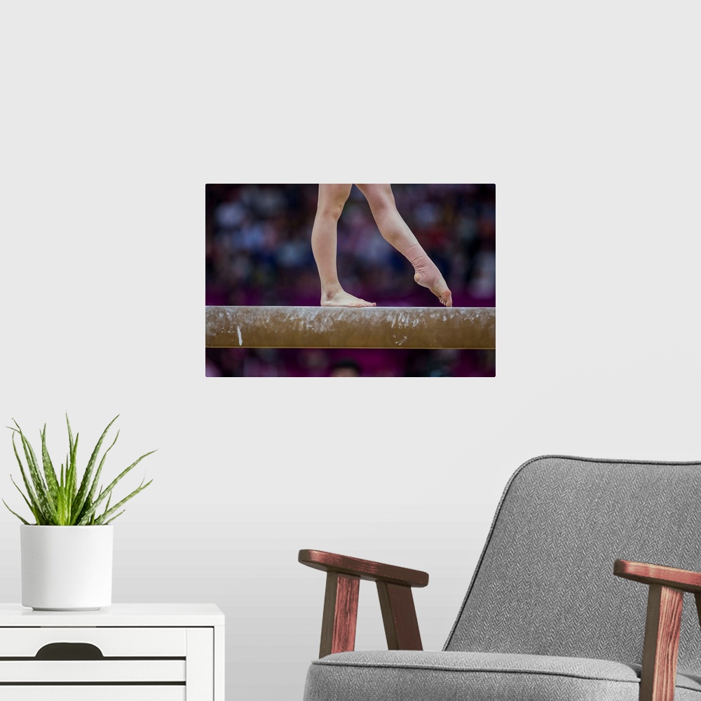 A modern room featuring Detail of gymnast  preforming on the balance beam during the women's gymnastics team finals at th...