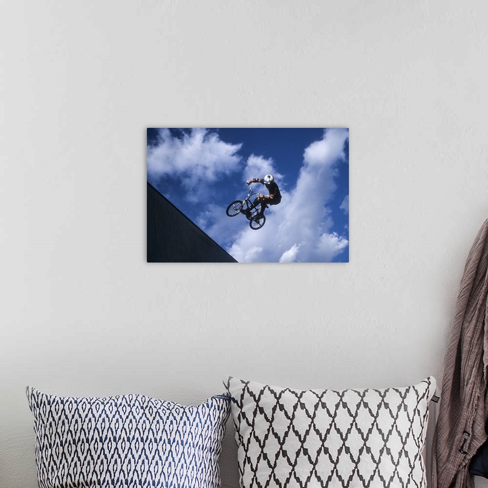 A bohemian room featuring Teenage boy flies over the vert on a BMX bike