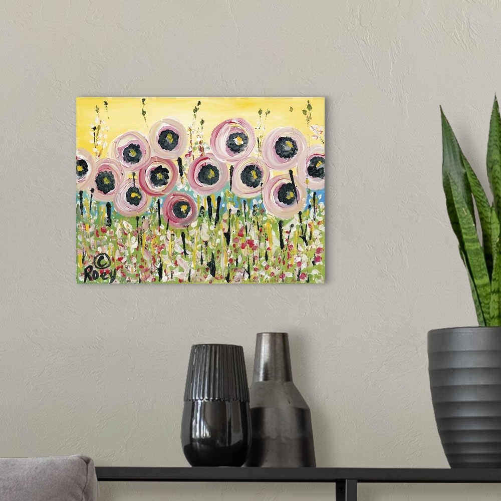 A modern room featuring Horizontal abstract painting of a field of flowers in textured colors of pink, green and yellow.