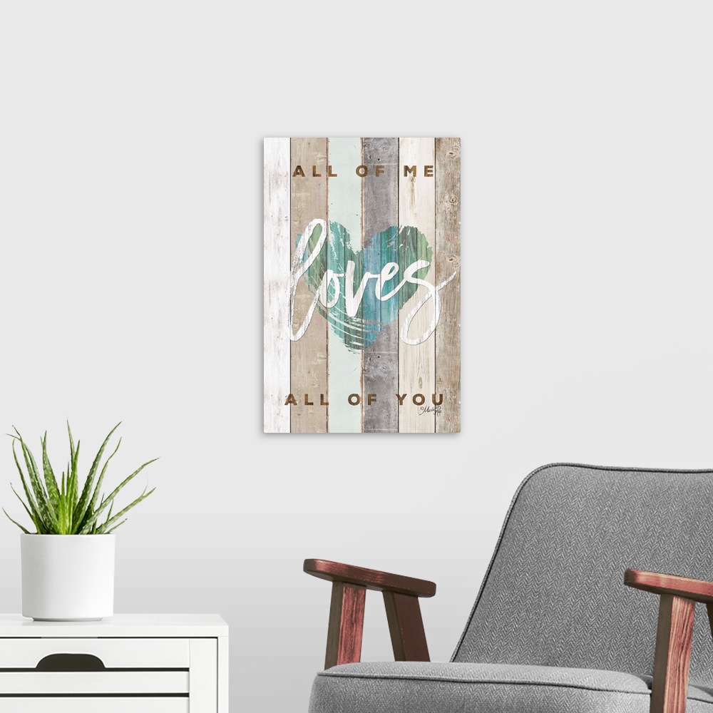 A modern room featuring "All of Me Loves All of You" with a blue/green heart design on wood plank background.