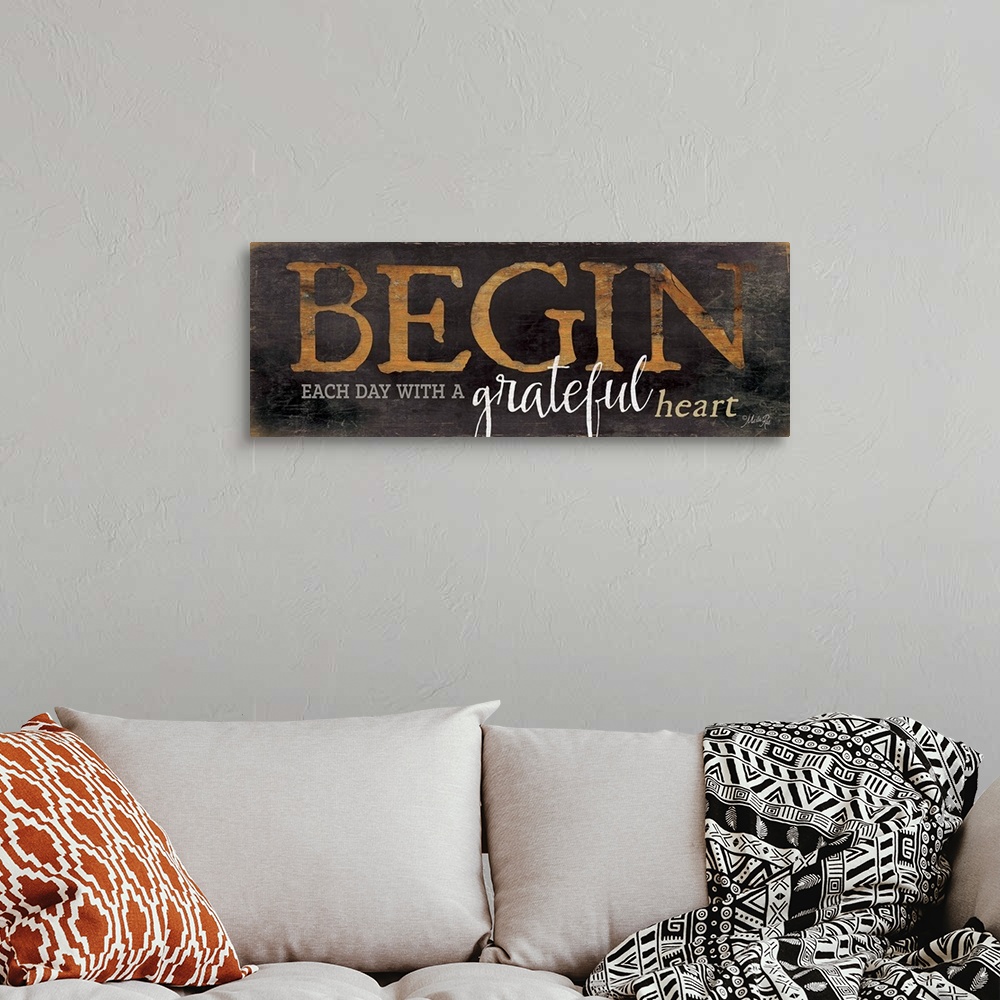 A bohemian room featuring Typography home decor art, with brown worn lettering against a dark weathered surface.