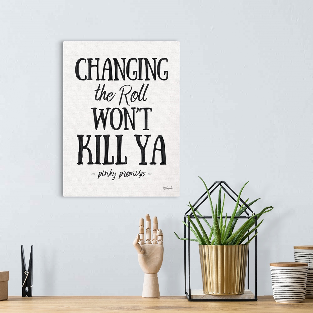 A bohemian room featuring Humorous decorative artwork featuring the phrase: Changing the roll won't kill ya, pinky promise.
