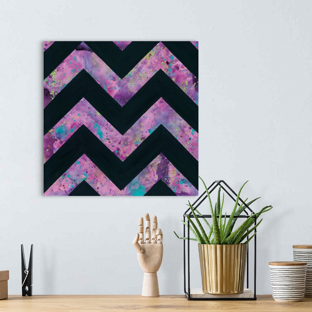 A bohemian room featuring Abstract art print of a chevron pattern in pink and blue contrasting with solid black.
