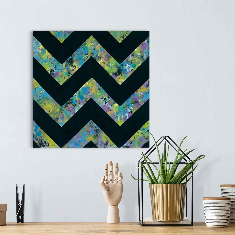 A bohemian room featuring Abstract art print of a chevron pattern in green, purple, and blue contrasting with solid black.