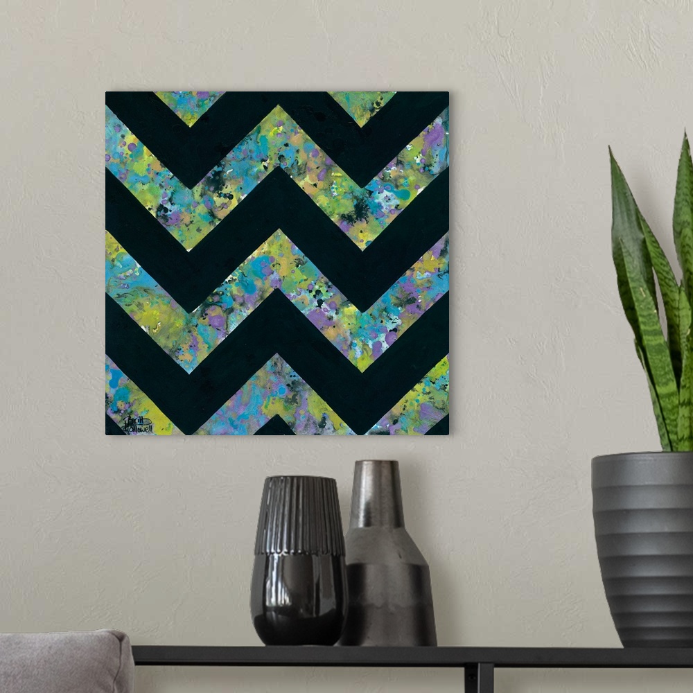 A modern room featuring Abstract art print of a chevron pattern in green, purple, and blue contrasting with solid black.