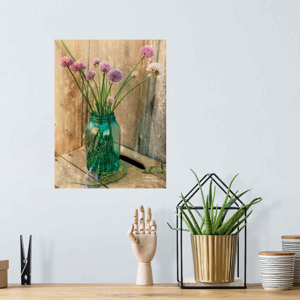 A bohemian room featuring Decorative artwork with a bouquet of purple flowers in a ball mason jar vase over a distressed wo...