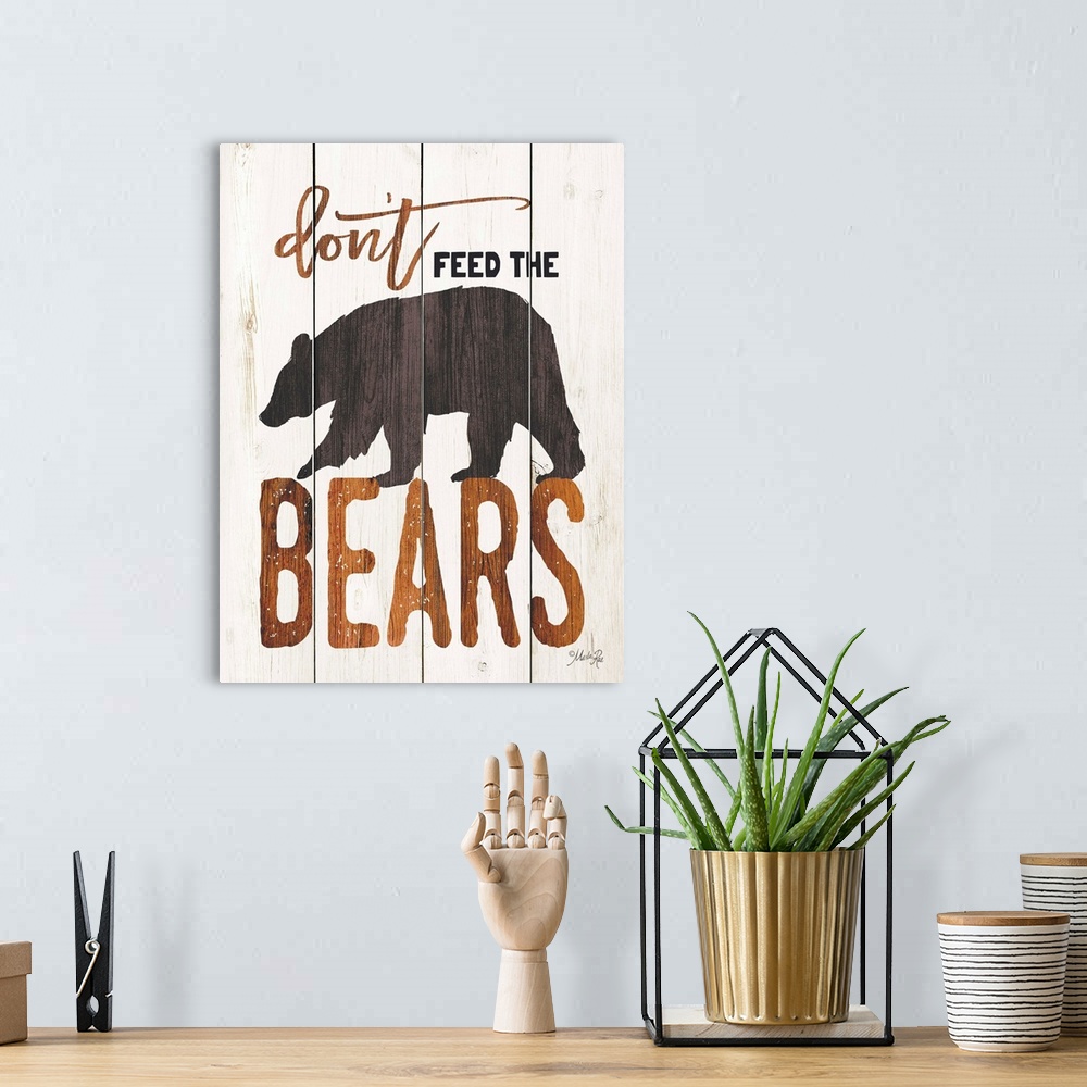 A bohemian room featuring Fun lodge-themed sign with a bear motif on a wooden board background.
