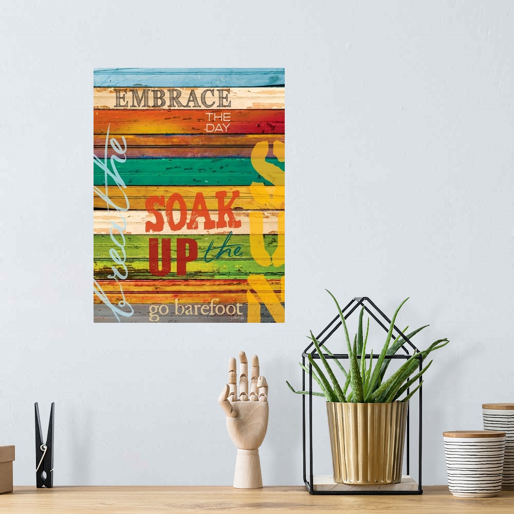 A bohemian room featuring Typography home decor art, with text in different fonts against a colorful wooden surface.