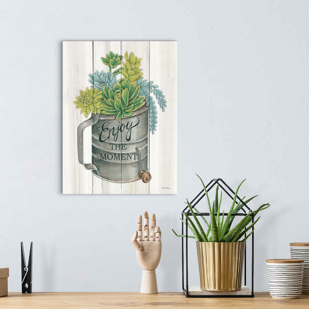 A bohemian room featuring The words, Enjoy the moment, are placed over an aged flour sifter filled with vibrant succulents ...