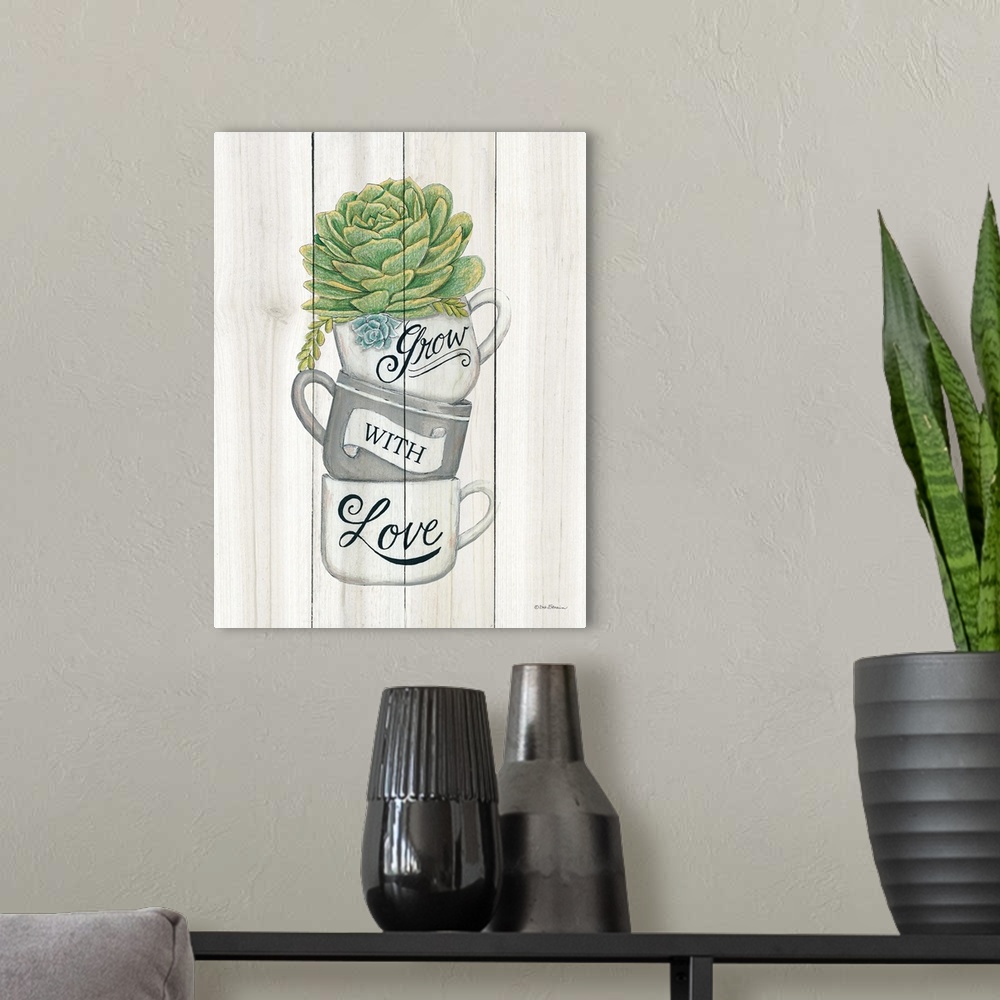 A modern room featuring The words, grow with love, are placed over stacked teacups with a succulent at the top.
