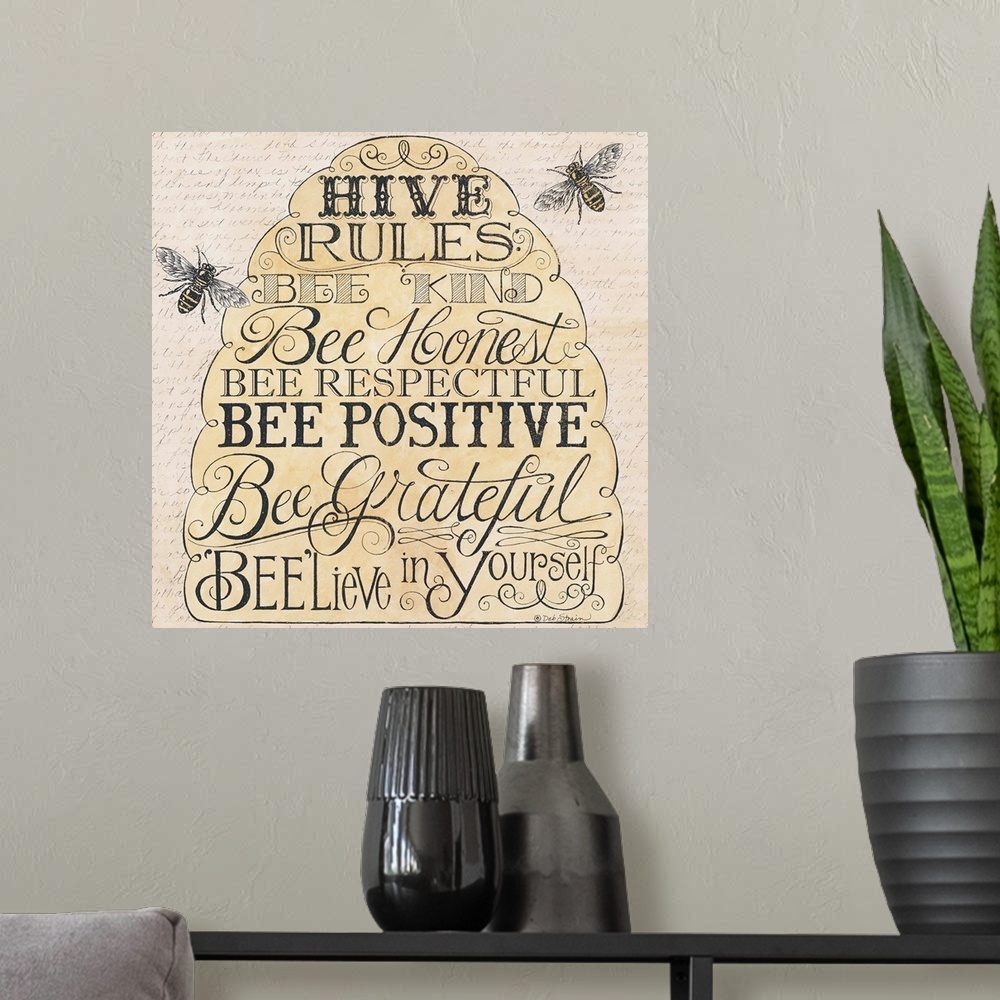 A modern room featuring Handlettered home decor art of bees hovering around a bee hive filled text.