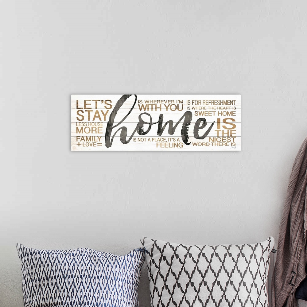 A bohemian room featuring Typography artwork of the word "home" in large black script, surrounded by family-themed words in...