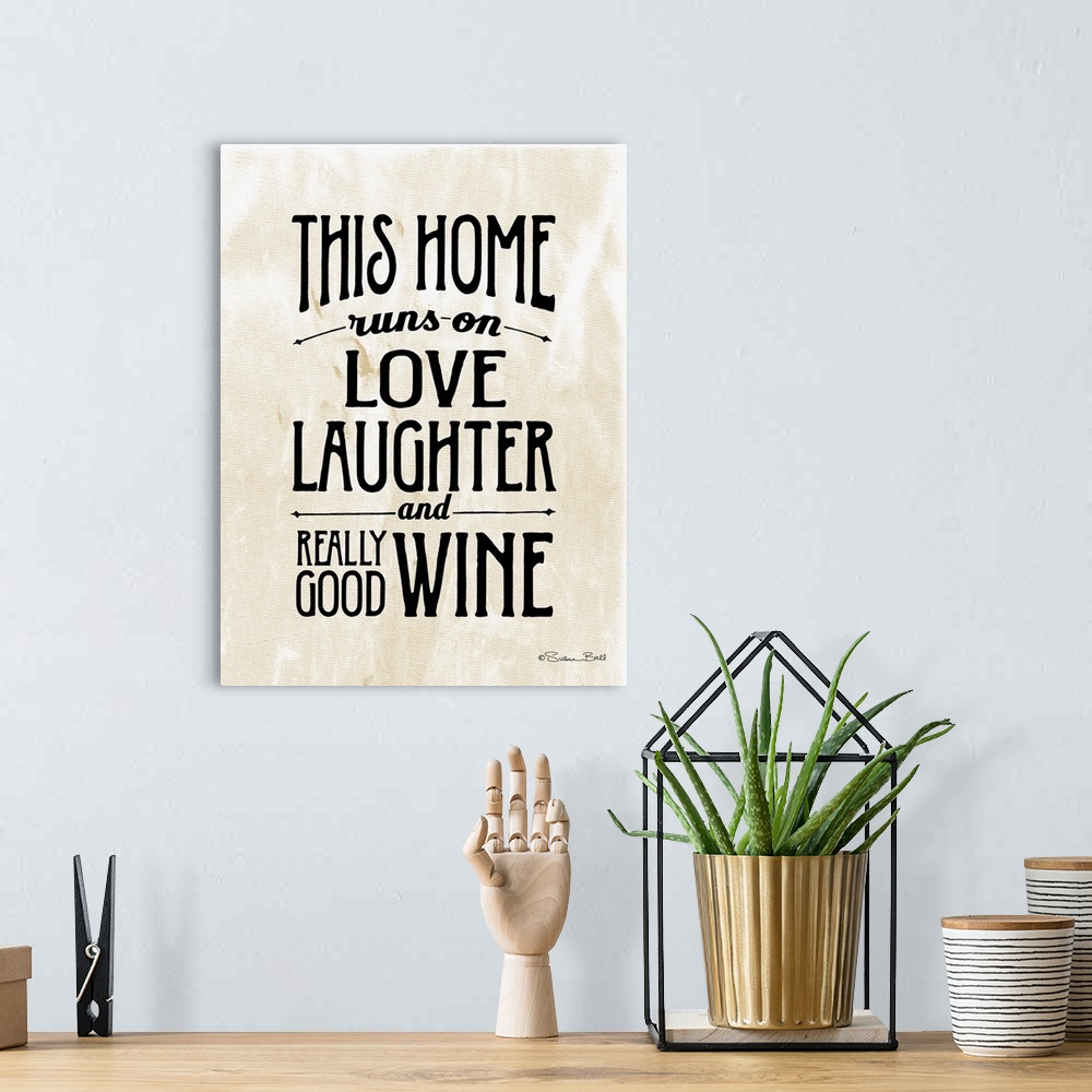 A bohemian room featuring Humorous artwork reading "This home runs on love, laughter, and really good wine" in black text o...