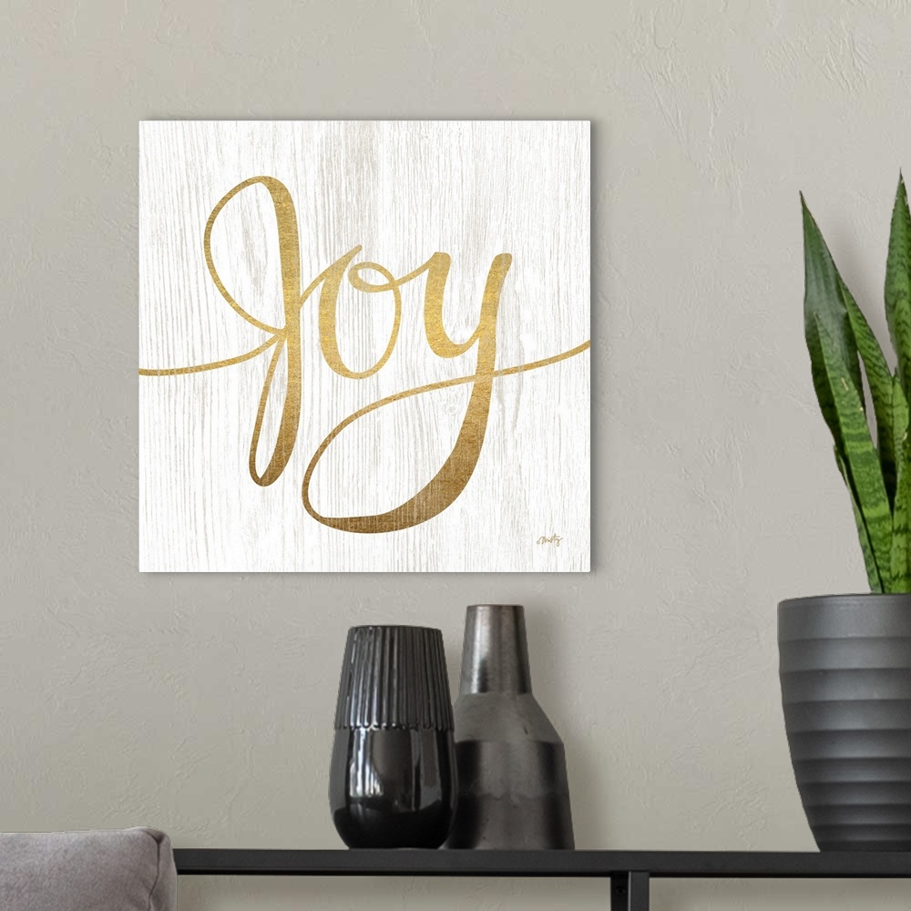 A modern room featuring The word Joy is gold colored letters over white background with wood grain texture overlaid.