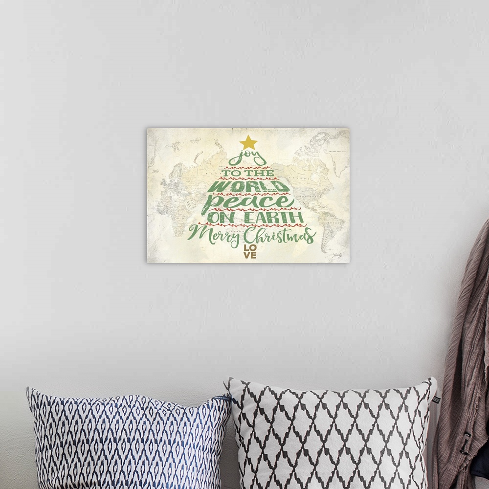 A bohemian room featuring Christmas themed typography art in the shape of a tree over an image of a world map.