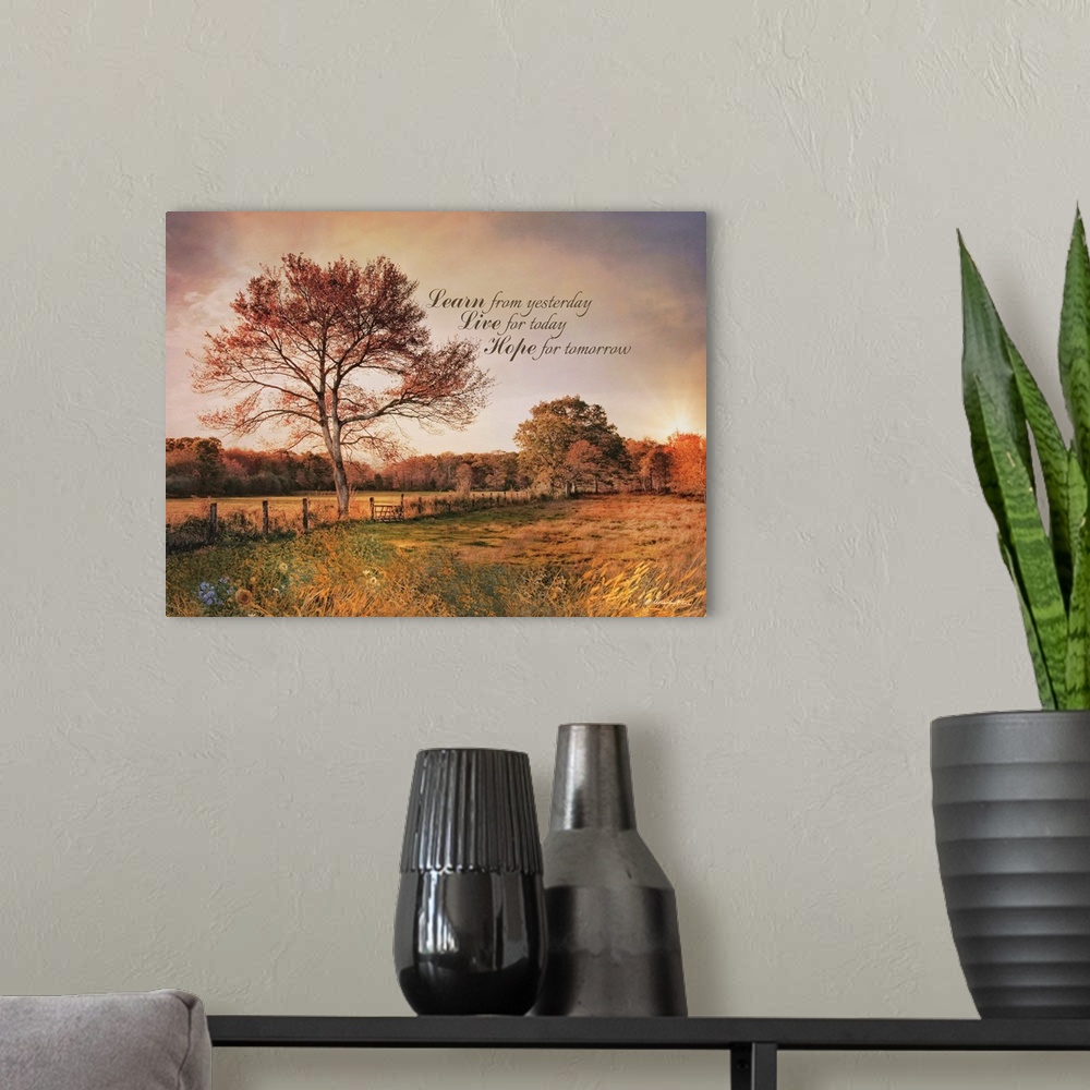 A modern room featuring An inspiration quote over an image of a field at sunset with tall trees and a fence.