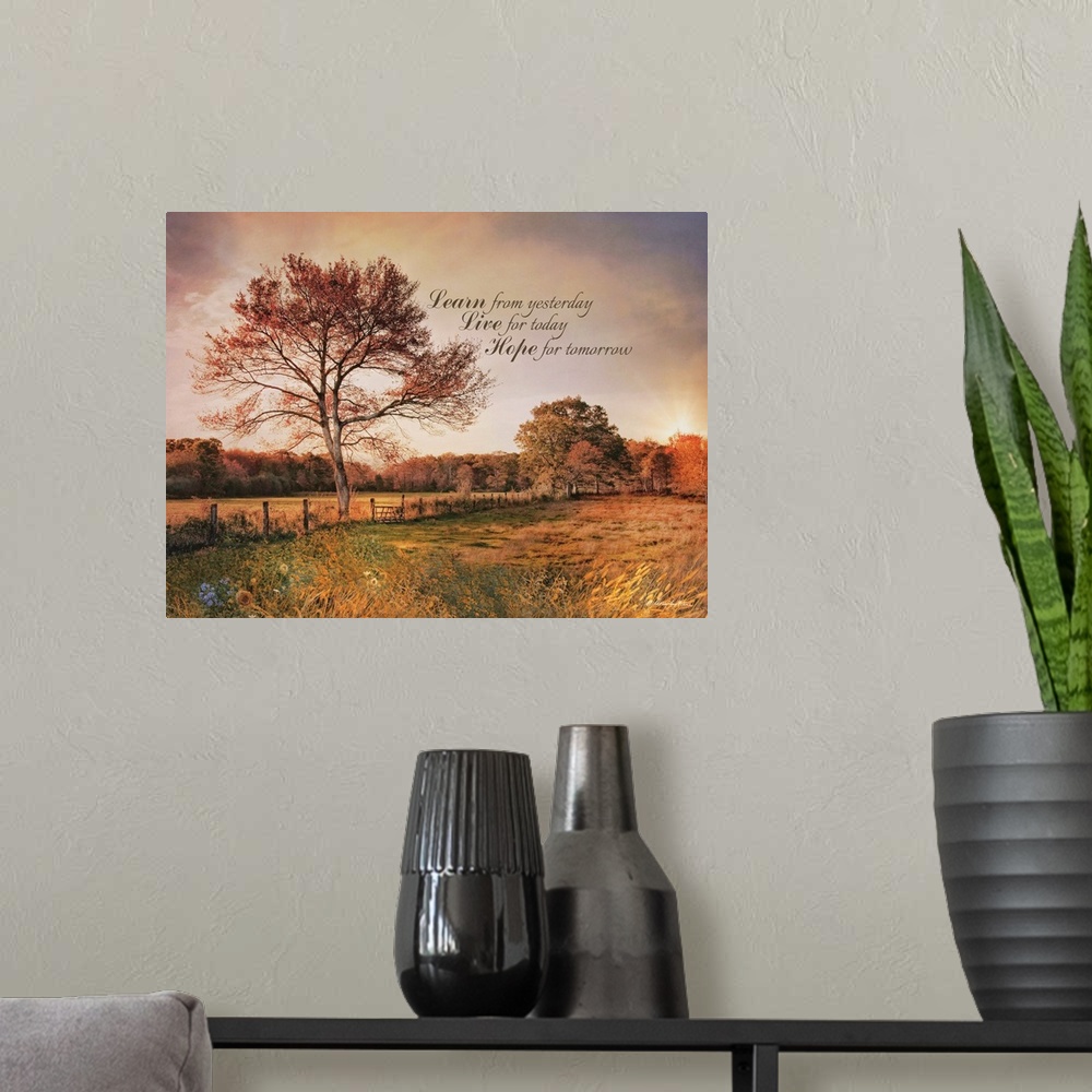 A modern room featuring An inspiration quote over an image of a field at sunset with tall trees and a fence.