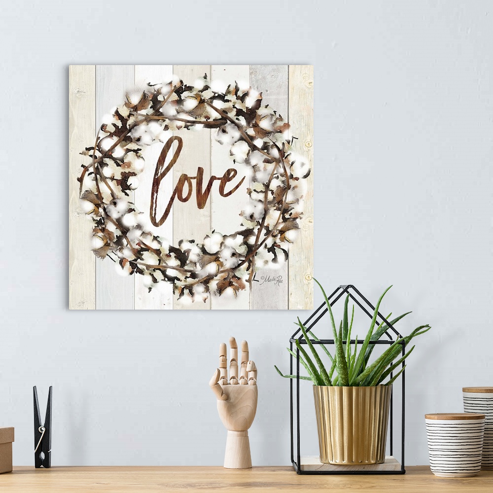 A bohemian room featuring "Love" in the middle of a wreath of cotton against a shiplap background.