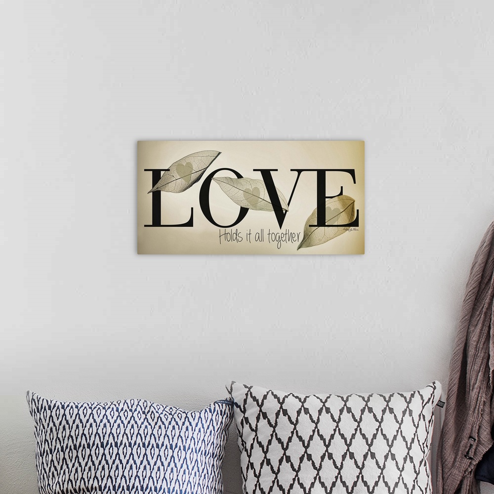 A bohemian room featuring Romantic typography art with a leaf design on neutral colors.