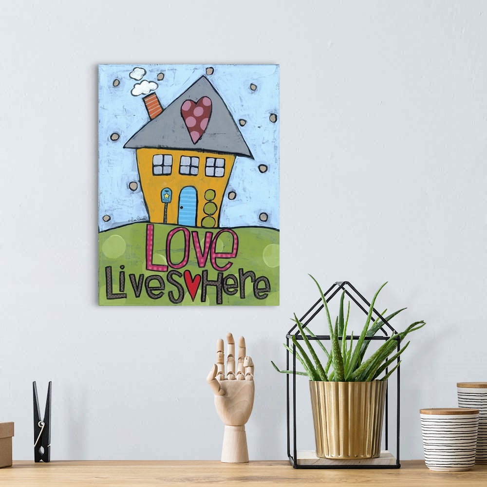 A bohemian room featuring Artwork of a cute house with a heart on the roof and the words "love lives here."