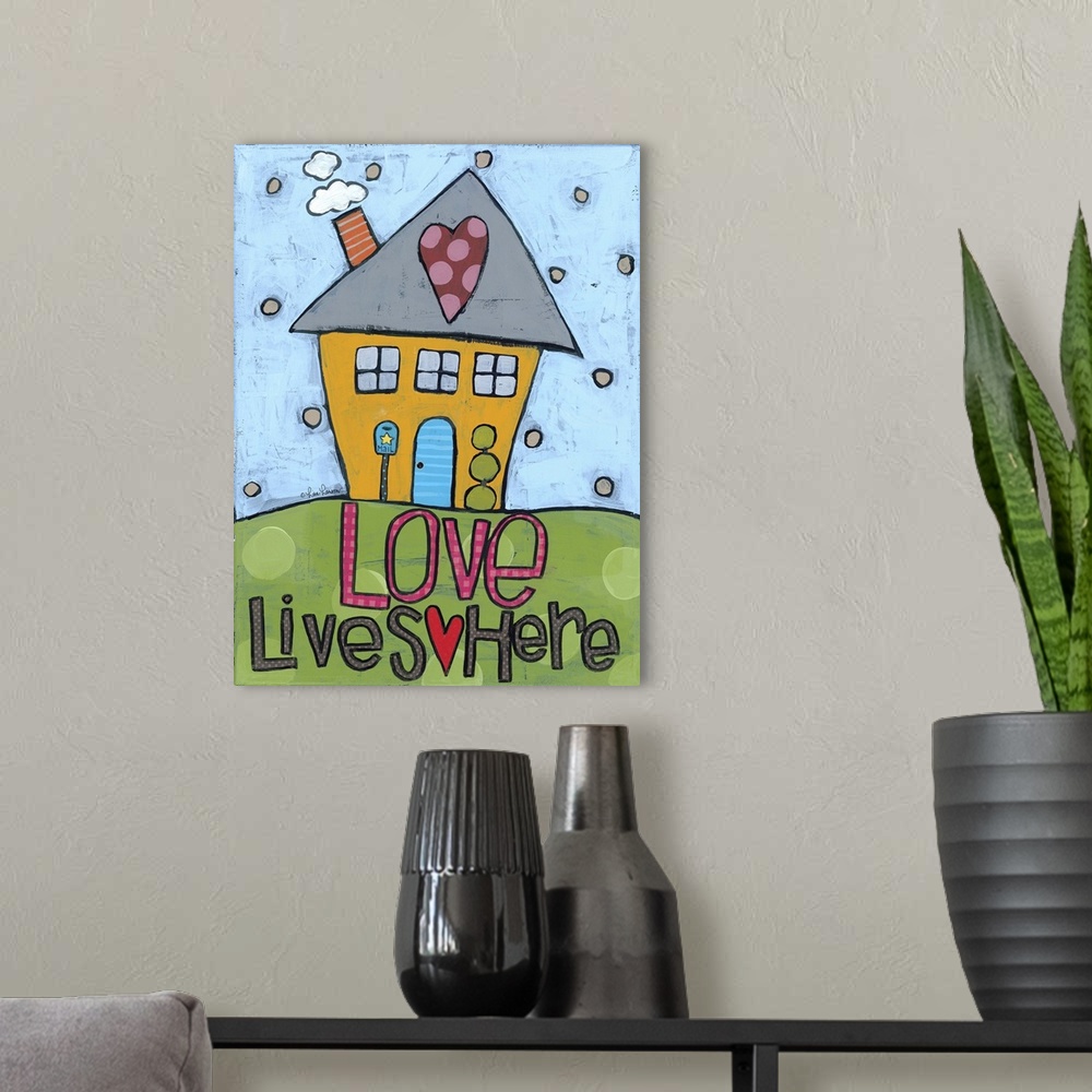 A modern room featuring Artwork of a cute house with a heart on the roof and the words "love lives here."