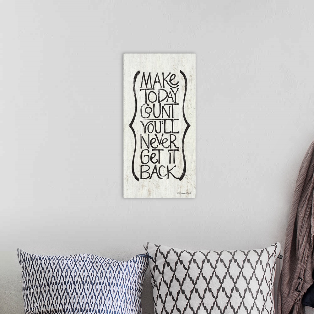 A bohemian room featuring Typography art of an inspirational sentiment in a vertical column with a parentheses motif.