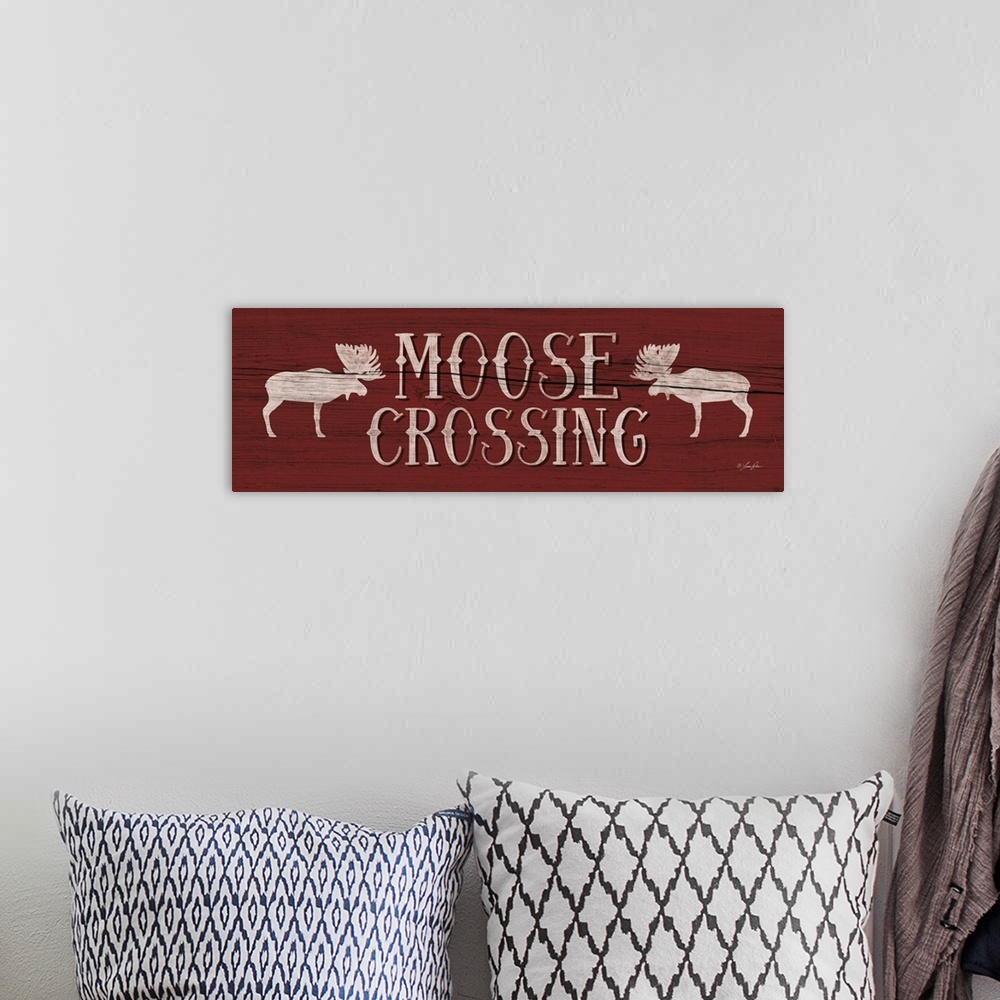 A bohemian room featuring Typography art reading "Moose Crossing" with two moose silhouettes on deep red.