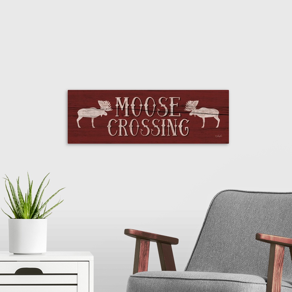 A modern room featuring Typography art reading "Moose Crossing" with two moose silhouettes on deep red.