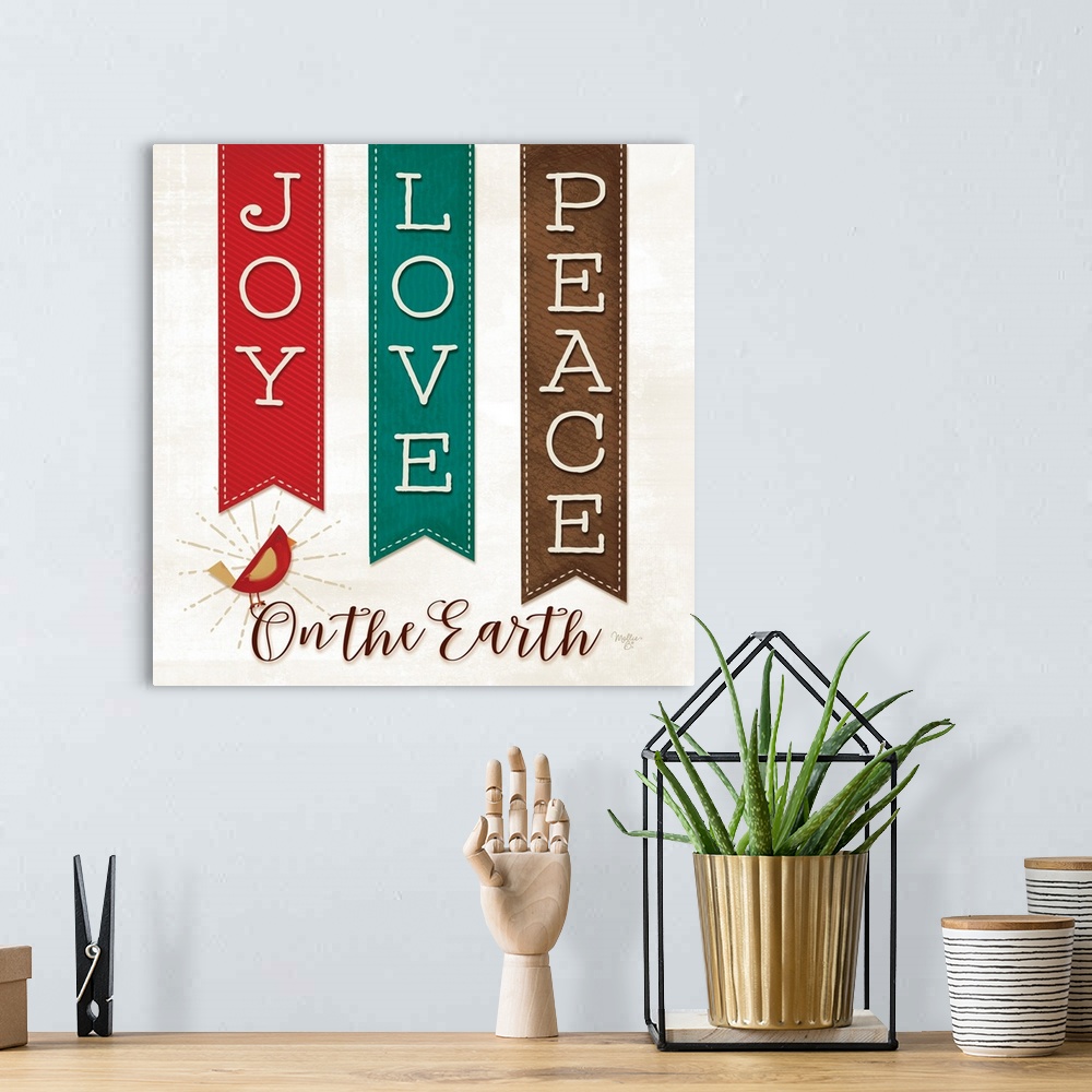 A bohemian room featuring This decorative artwork features festive banners with the words: Joy, Love, and Peace. Underneath...