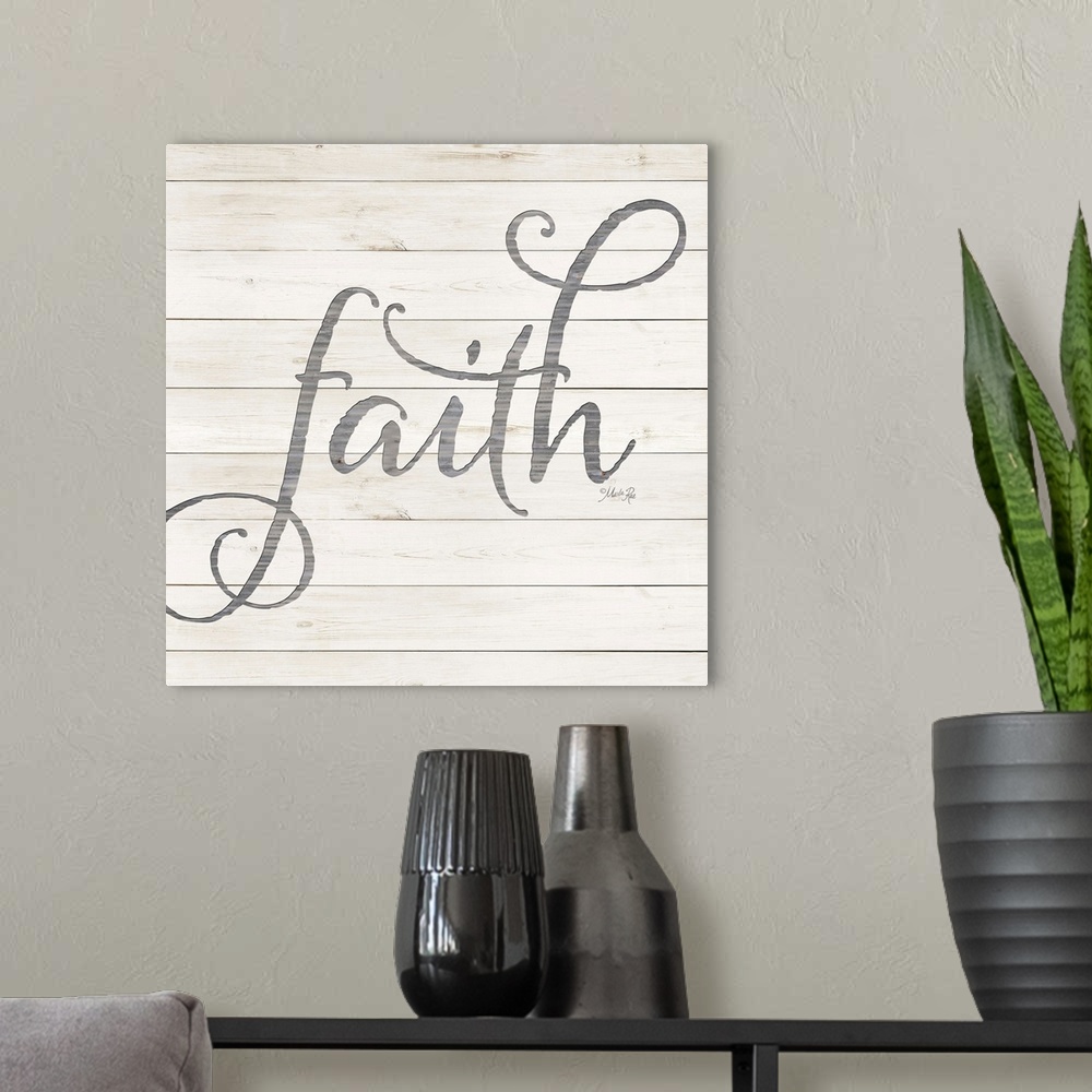 A modern room featuring "Faith" situated on a white shiplap background.
