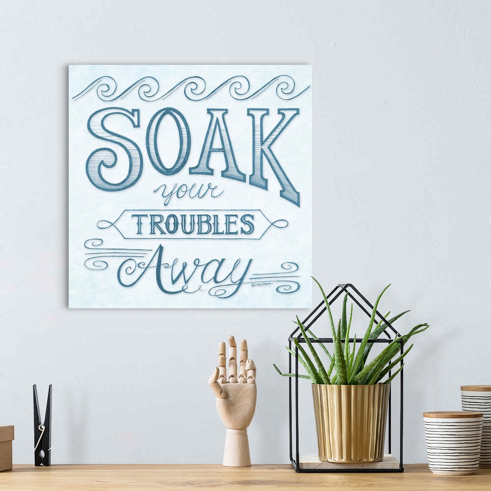 A bohemian room featuring Handlettered home decor art for a bathroom, with dark blue lettering against a distressed light b...