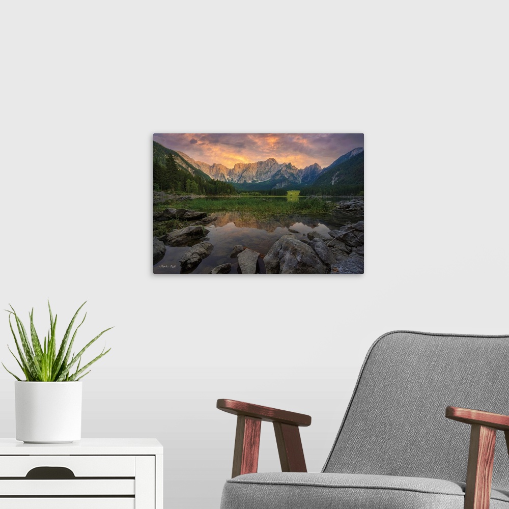 A modern room featuring Photo of a calm mountain lake under clouds glowing in sunset light.