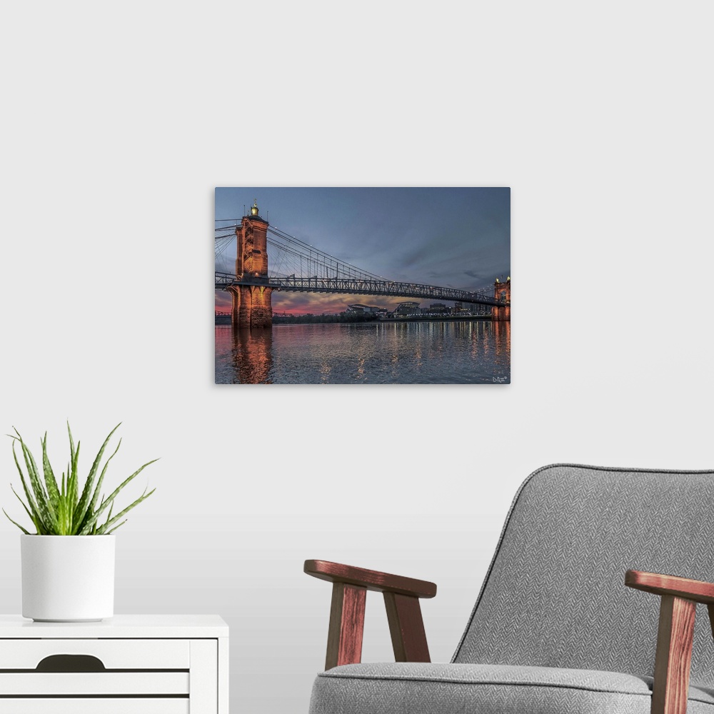 A modern room featuring The John A. Roebling Suspension Bridge over the Ohio River in the early evening.