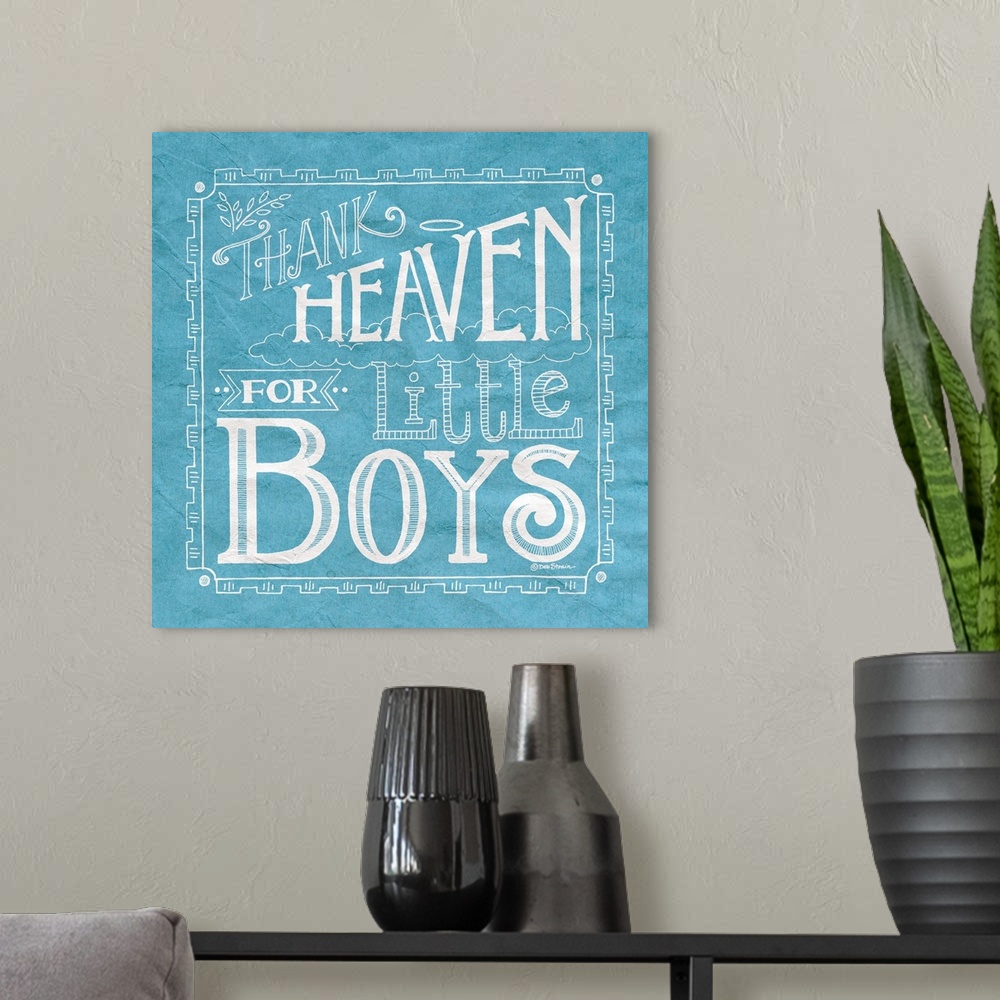 A modern room featuring Handlettered home decor art for a boy's room, with white lettering against a distressed blue back...