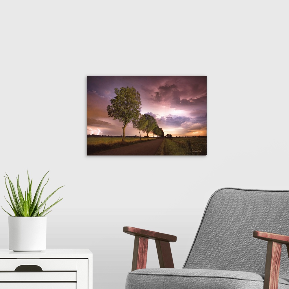 A modern room featuring Lightning in the pink clouds over a tree-lined road in the countryside.