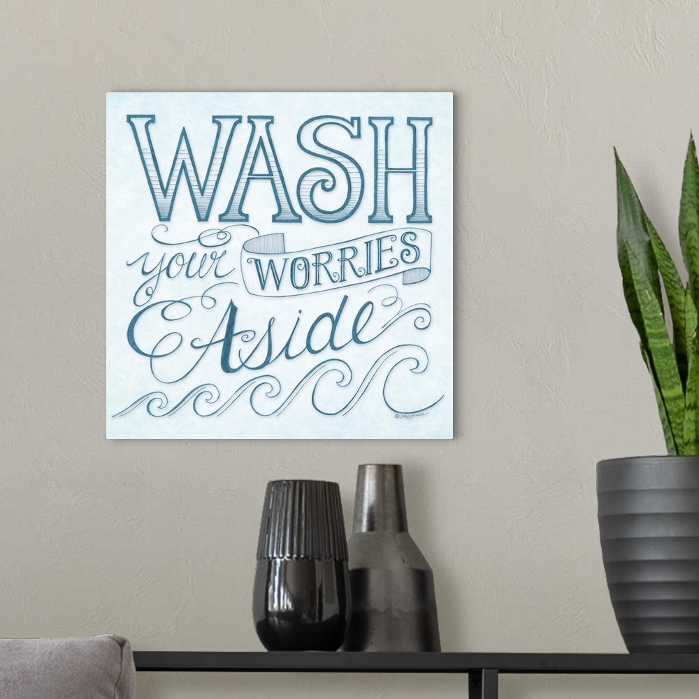 A modern room featuring Handlettered home decor art for a bathroom, with dark blue lettering against a distressed light b...