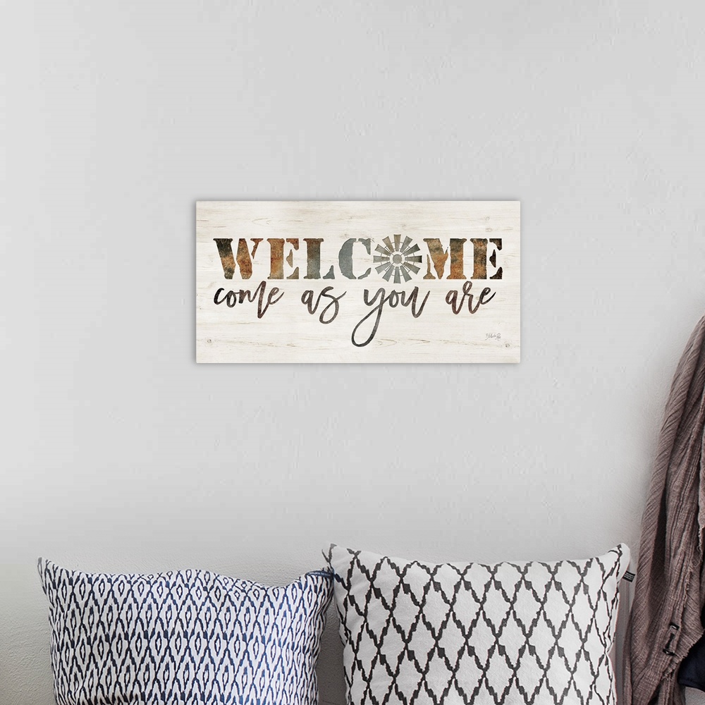 A bohemian room featuring "Welcome Come As You Are" on a white washed wood background.
