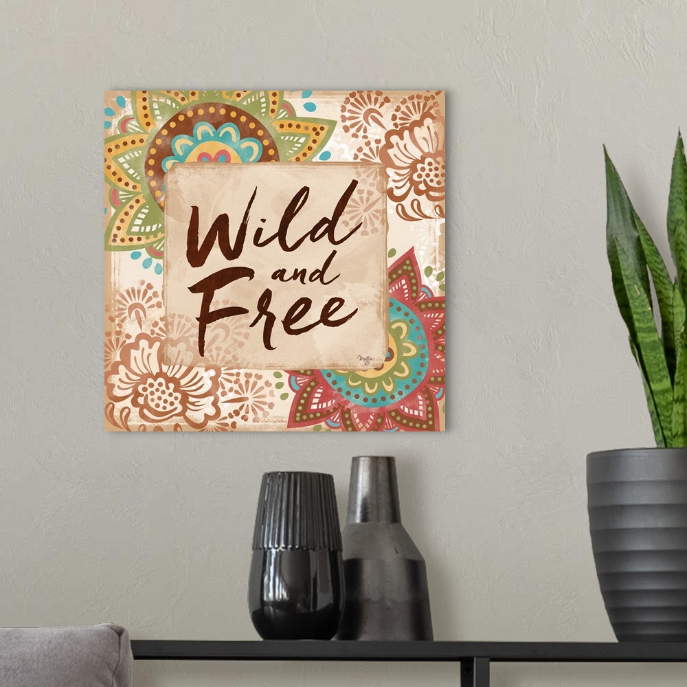 A modern room featuring "Wild and Free" hand written and framed by colorful floral mandalas.
