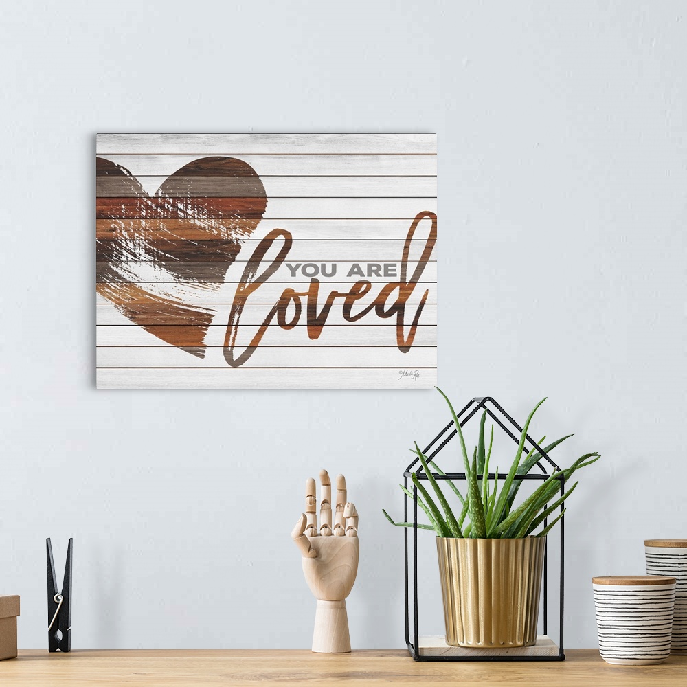 A bohemian room featuring Typography art reading "You are loved" with a heart design, appearing to be painted onto a board ...