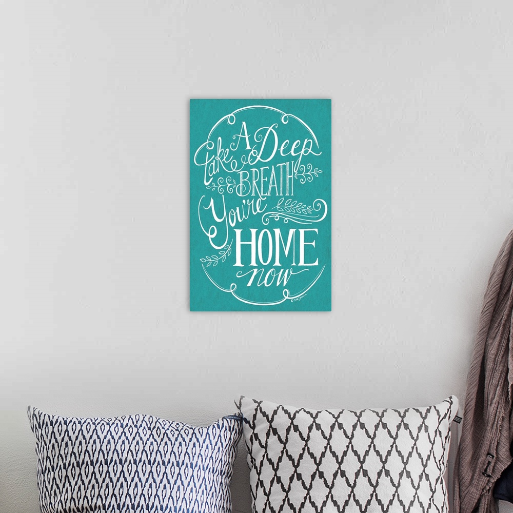 A bohemian room featuring Handlettered home decor artwork, with white lettering against a teal background.