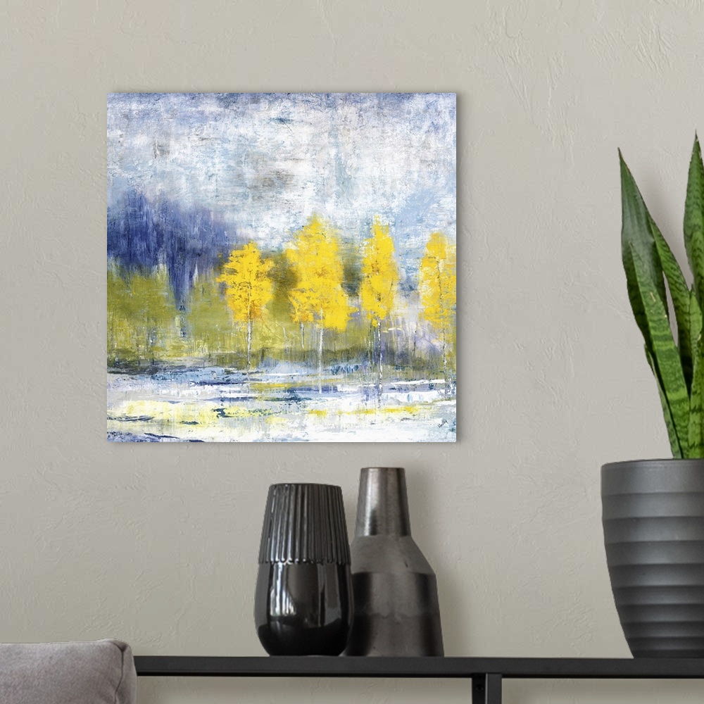 A modern room featuring Brilliant landscape of a row of yellow leaved trees before a forest and blue sky.