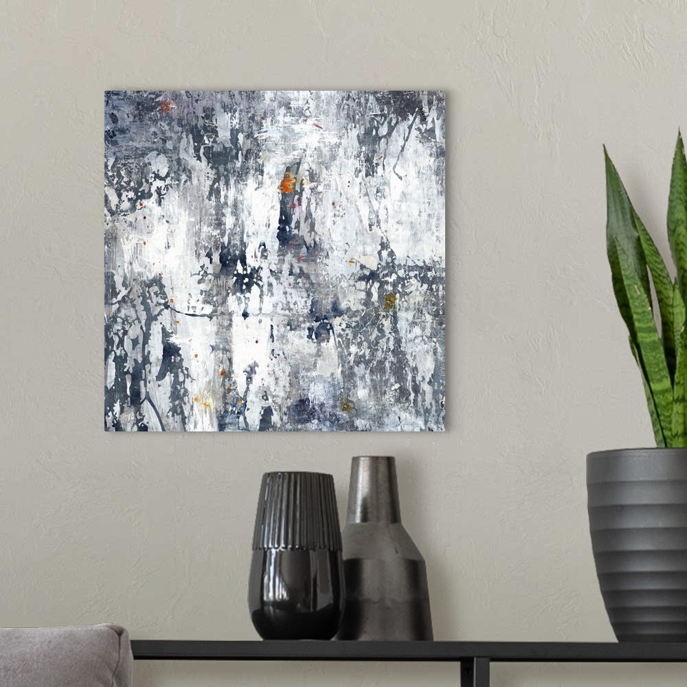 A modern room featuring Large gray, white, and indigo abstract art with hints of orange, yellow, and gold throughout.