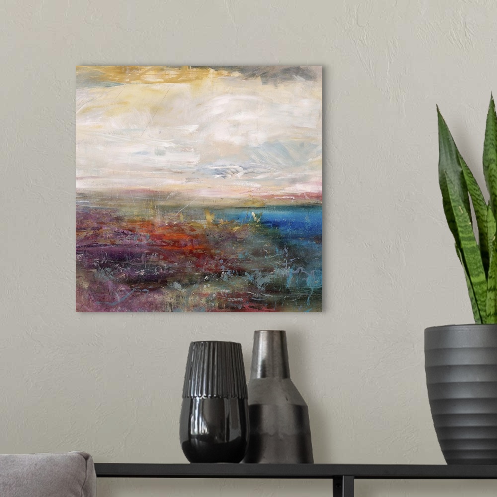 A modern room featuring Abstract painting of a golden cloudy sky above a vibrant field of wildflowers and a deep blue bod...