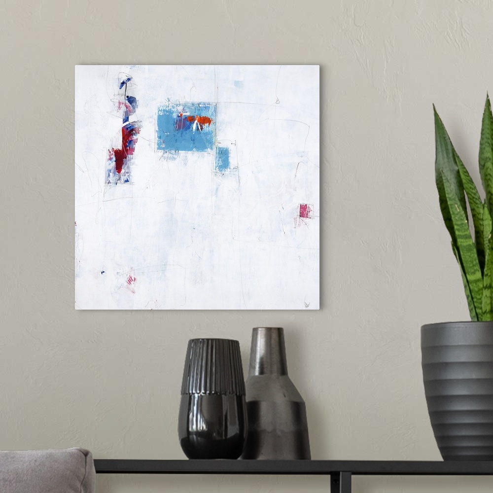 A modern room featuring Contemporary abstract painting using splashes of vibrant blue and red against a neutral environment.