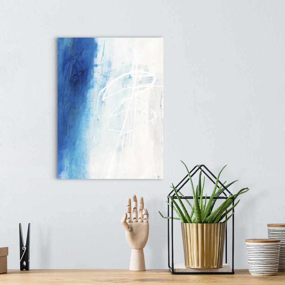 A bohemian room featuring Contemporary abstract painting using white and vibrant blue in vertical formation.