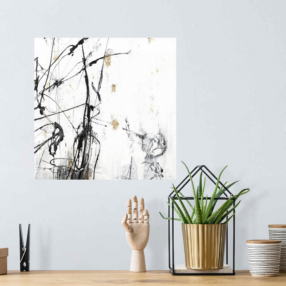 A bohemian room featuring Square abstract painting in white, gray, black, and gold with thin lines sporadically on top of t...